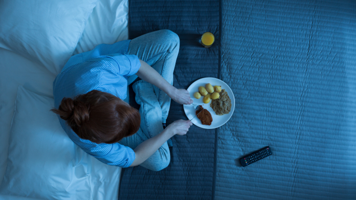 Woman who eats at night on her bed